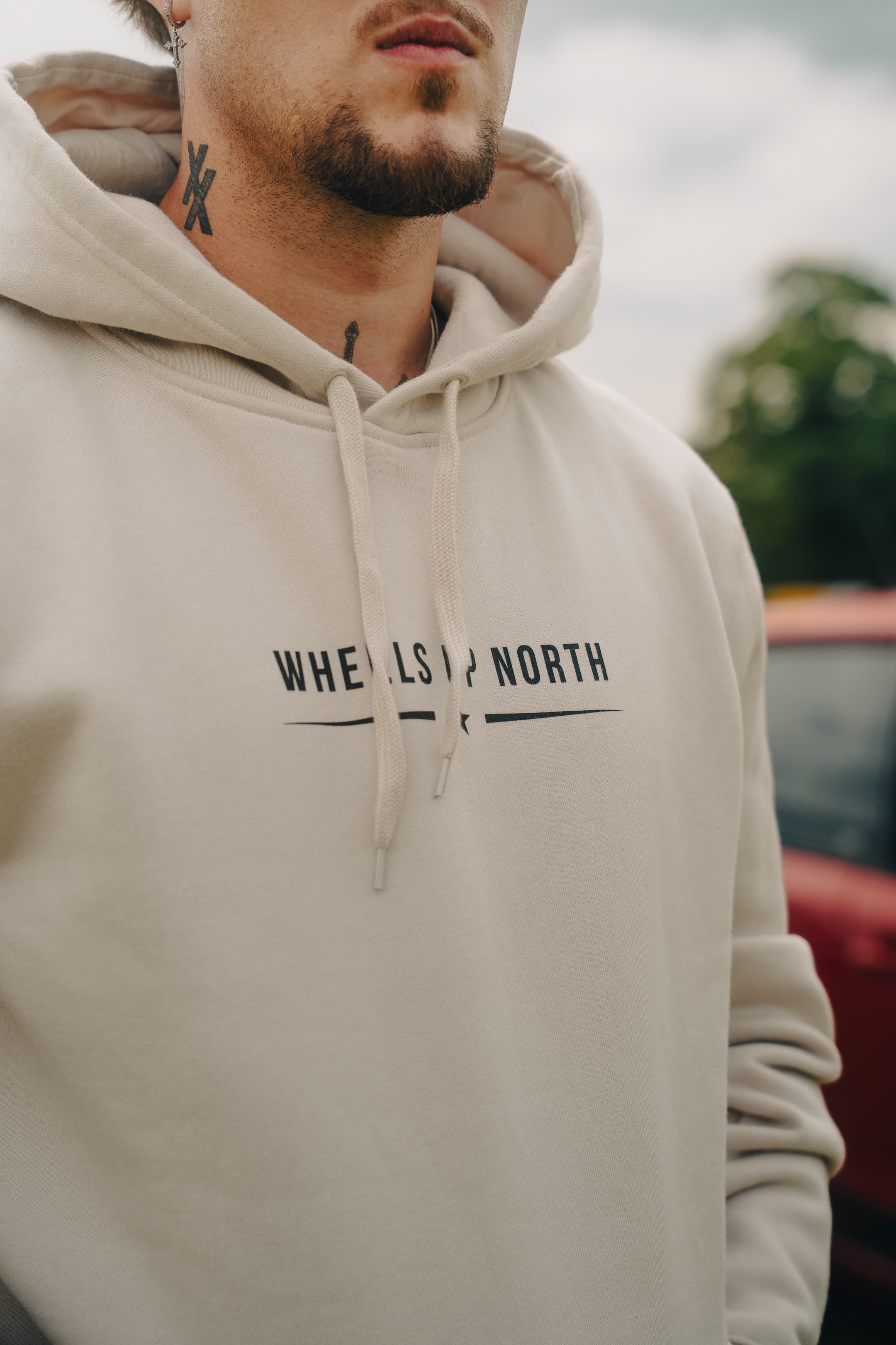 Grass 'Routes' Hoodie - Bone - close-up of the wheels up north chest logo on the bone hoodie