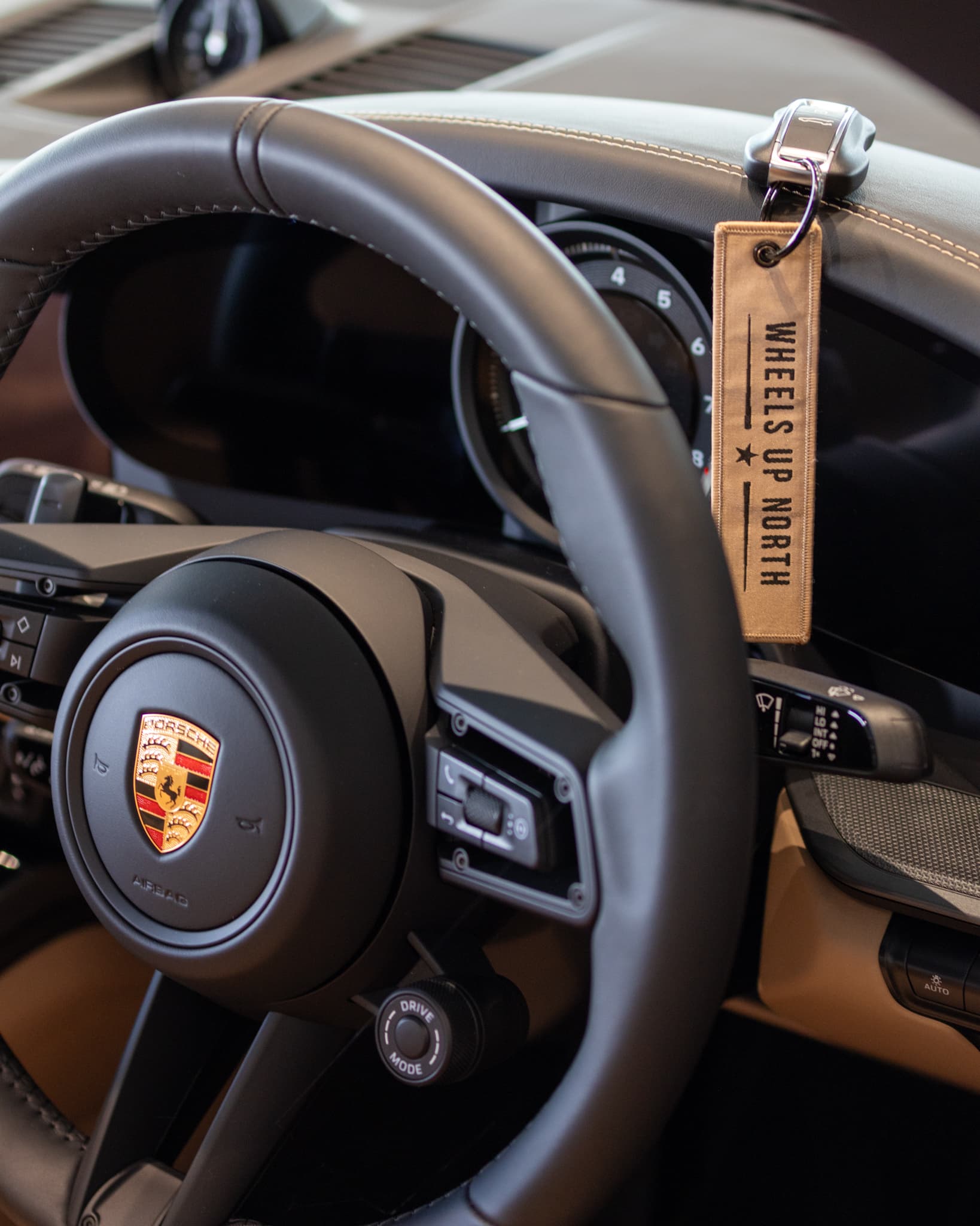 Wheels Up North Flight Tag - sand wheels up north flight tag hanging from a porsche key by the steering wheel